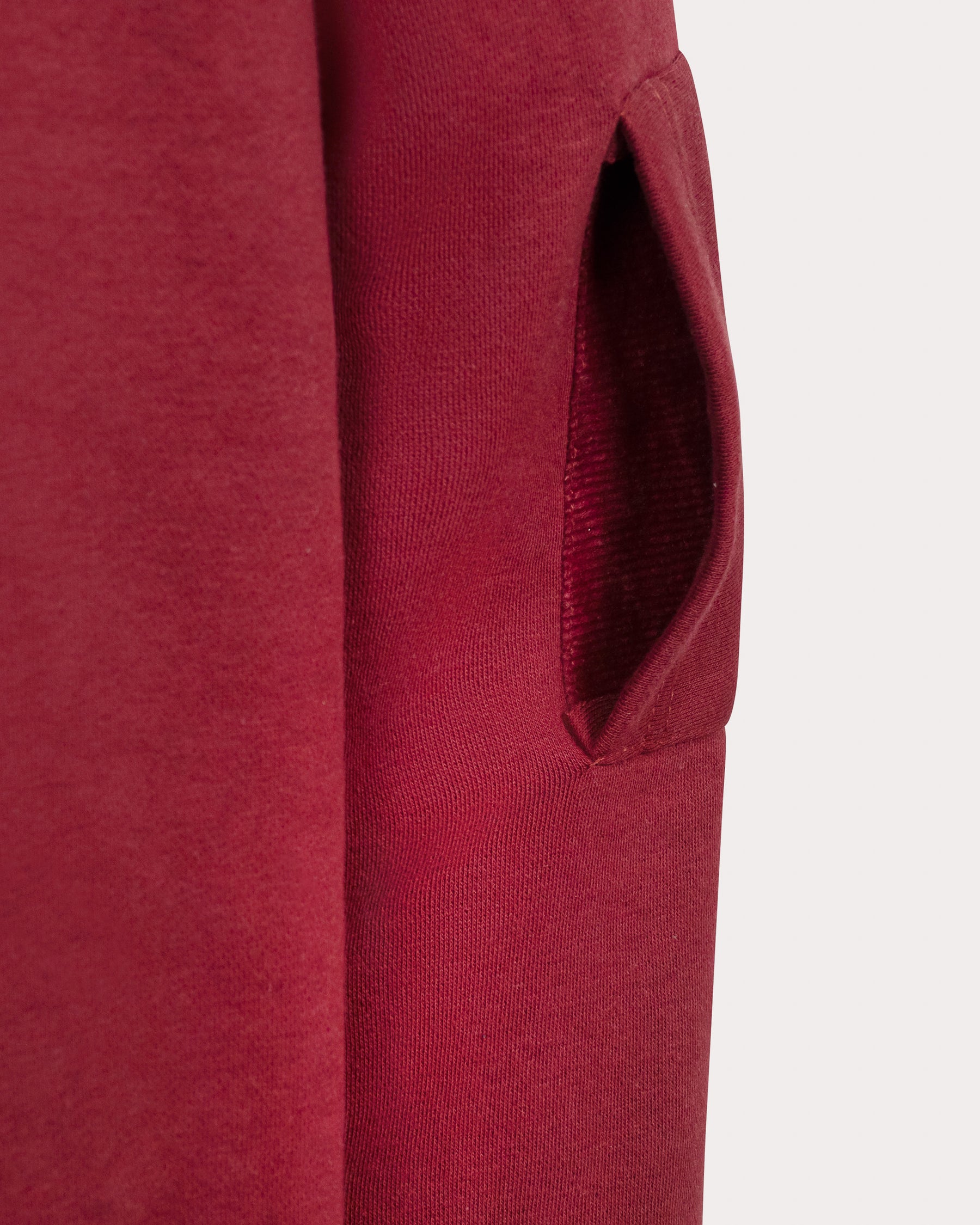 Close-up of the sleeve pocket on a maroon SOLACE Collective COVE hoodie.